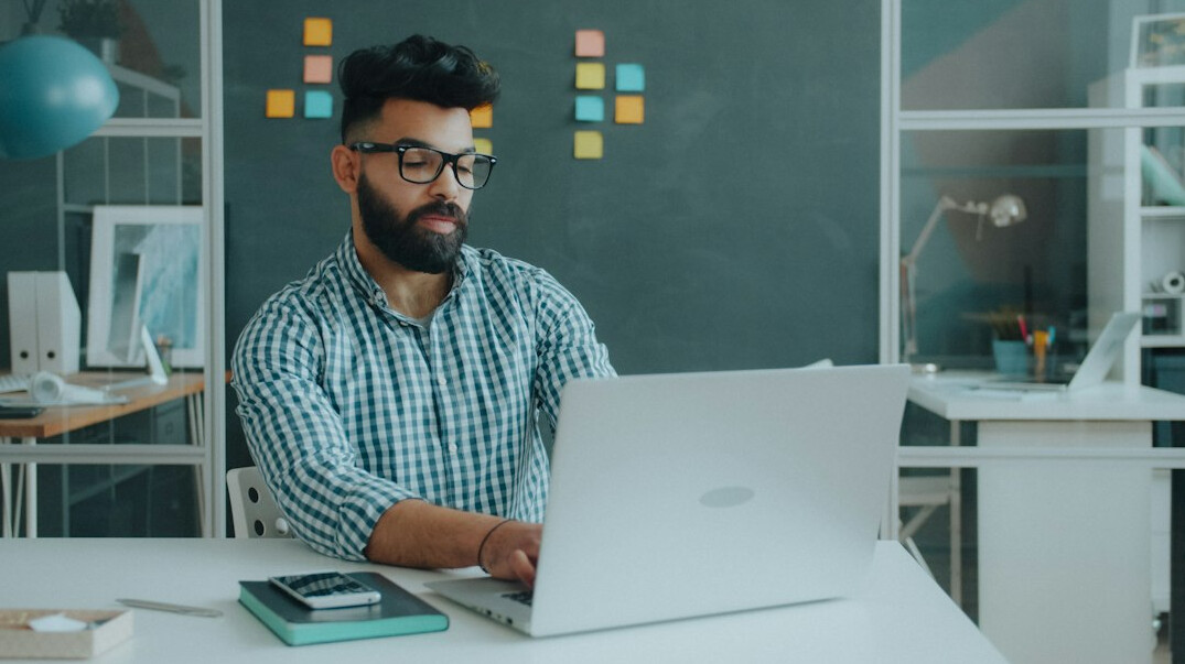 Software developer working on insurance platform code on a laptop